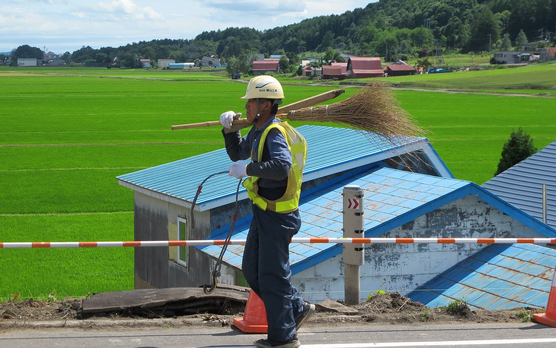 A worker in a high-visibility vest carrying gear